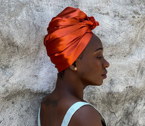 satin headwrap in sunset orange wrapped in a turban style on blacjk woman - vicky an style