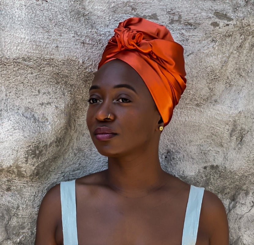 Satin Headwrap in sunset orange styled on black woman facing forward wrapped in a turban style - Vicky An Style